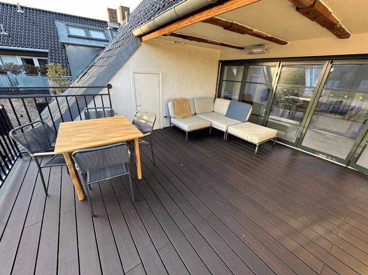 Dachterrasse mit edlen Bambus-Terrassendielen in dunkelbraunem Espresso-Ton, hochwertiger Outdoor-Lounge und Esstisch aus Holz. Die pflegeleichten, wetterfesten Bambusdielen sorgen für eine moderne und nachhaltige Gestaltung im Außenbereich. Ideal für Balkon, Terrasse oder Garten.