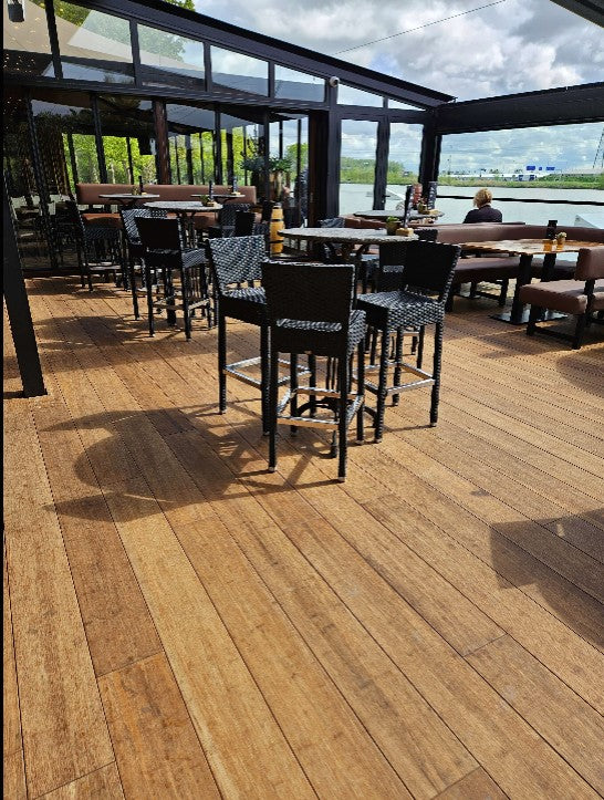 Außenterrasse eines Restaurants mit langlebigen Closed Decking Bambus-Terrassendielen Colon von aMbooo und stilvoller Sitzmöblierung.
