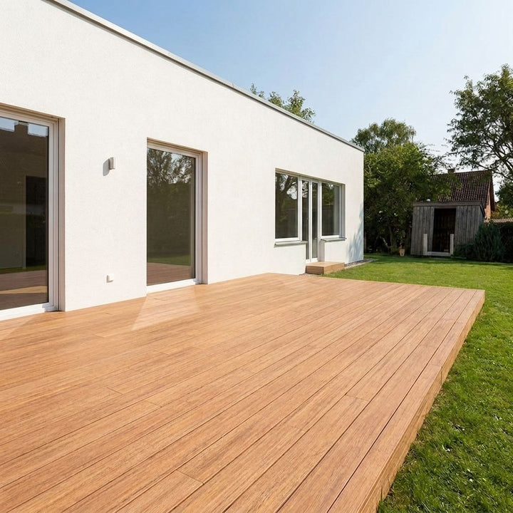 Große Closeddeck AMBOOO-Terrasse  an einem modernen weißen Wohnhaus mit Garten.