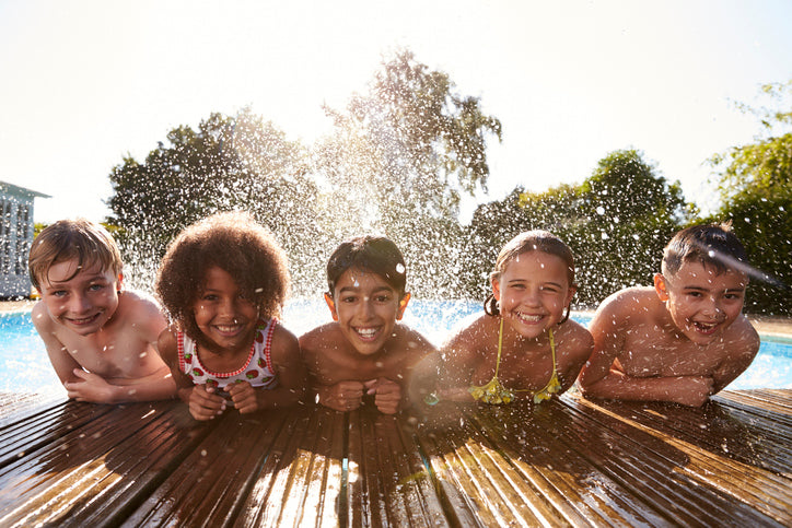 Kinder am Pool auf einer Terrasse mit Bambus-Terrassendielen. Der natürliche Terrassenbelag eignet sich für moderne Gärten und familienfreundliche Außenbereiche.