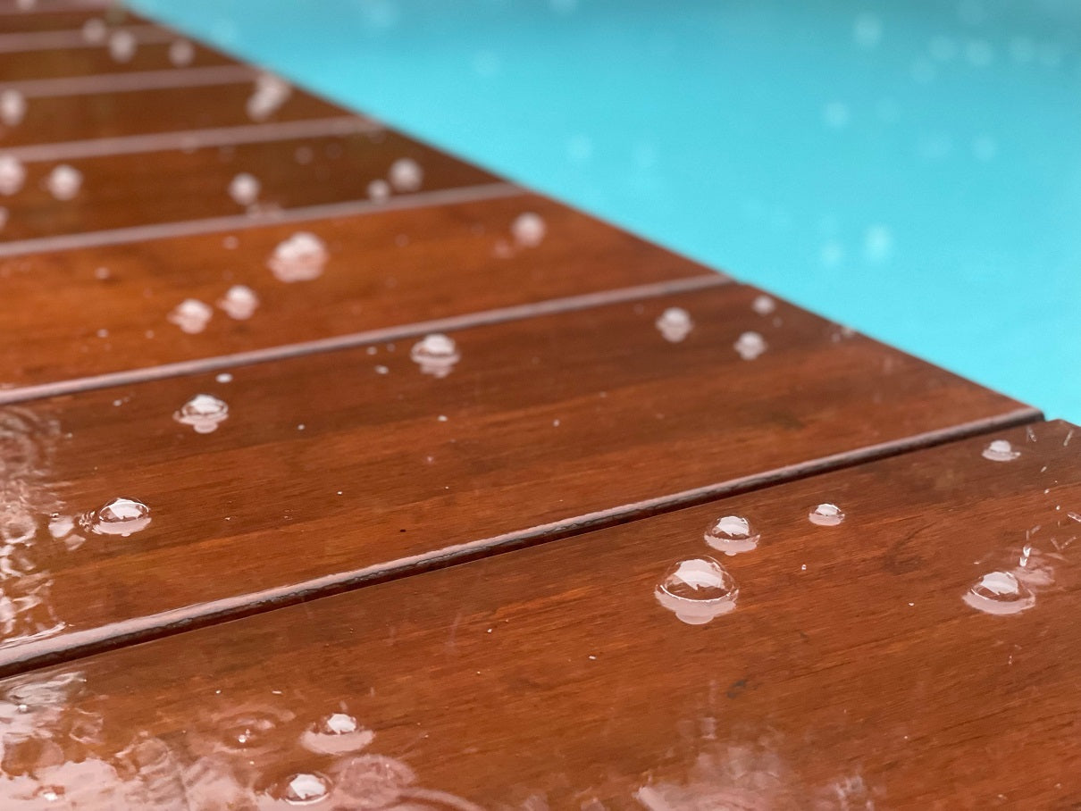 Rutschhemmende Bambusdielen im Regen  angrenzend an einem Pool.