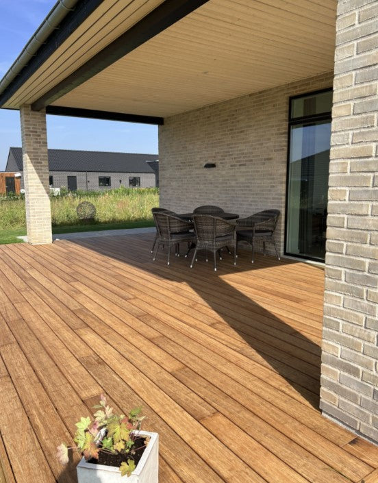 Großzügige Bambusholzterrasse mit hochwertigen  Terrassendielen in der Farbe Sand, an einem modernen Klinkerhaus. Die überdachte Terrasse mit Sitzgruppe schafft einen geschützten Außenbereich und verbindet Wohnkomfort mit natürlicher Optik.