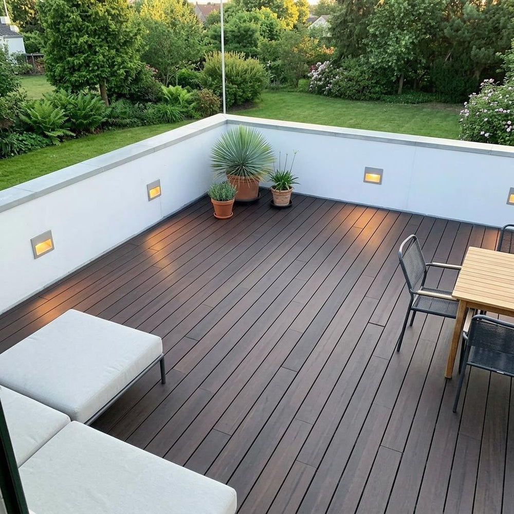 Großzügige Dachterrasse mit dunkelbraunen AMBOOO-Terrassendielen, Sitzmöbeln, Pflanzkübeln und Blick in einen grünen Garten.