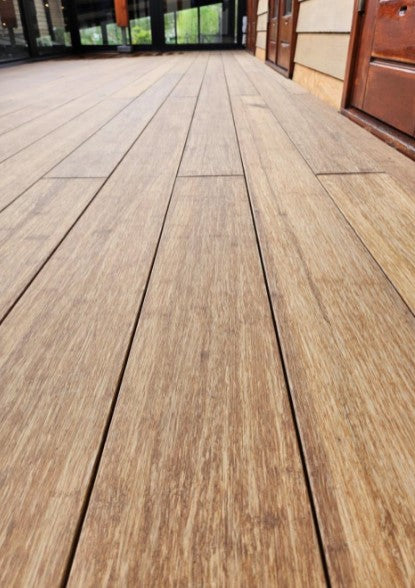 Ein AMBOOO Closeddeck Bambus Terrassenbelag mit einer Microfuge verlegt auf einem Balkon - Nahaufnahme- vorgeölt in der Farbe Sand.