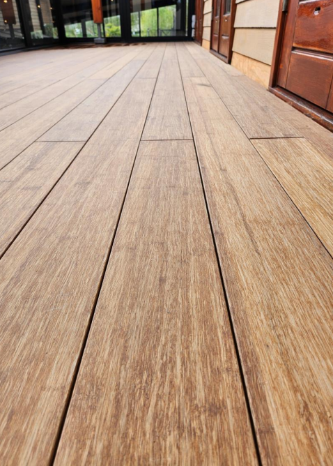 Ein aMbooo Bambus Terrassenbelag mit einer Microfuge verlegt auf einem Balkon - Nahaufnahme- vorgeölt in der Farbe Sand aus der Serie Closed Deck.