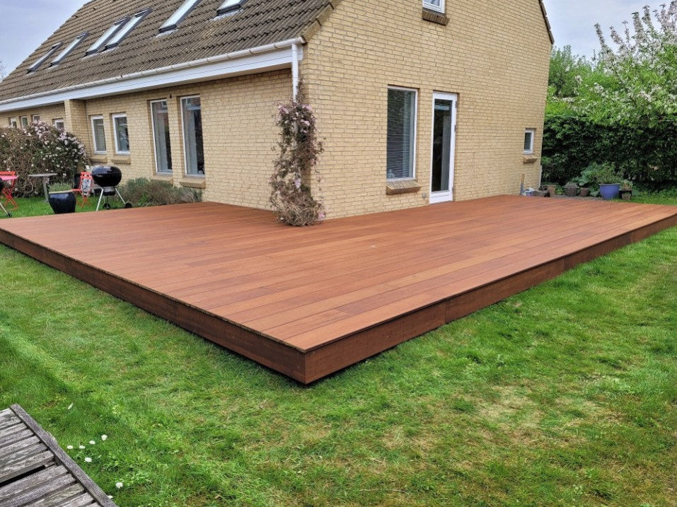 Moderne, großzügig angelegte Holzterrasse mit hochwertiger Unterkonstruktion als stilvolle Erweiterung des Wohnbereichs im Garten.