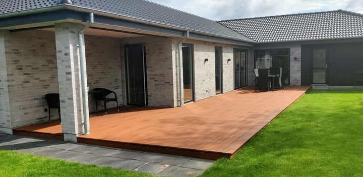 Großzügige -Terrasse an einem modernen Einfamilienhaus mit gepflegtem Rasen und Sitzbereich.