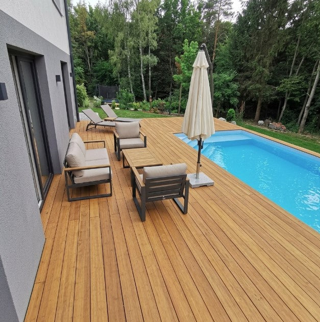 Großzügige Poolterrasse aus Campoverde  Sand AMBOOO Terrassendielen mit Loungemöbeln und Sonnenliegen am Wohnhaus.