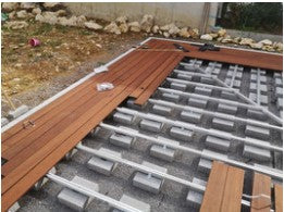 Aufbau einer Terrasse mit einer  Unterkonstruktion aus Aluminium und teilweise verlegten Terrassendielen aus Bambus. Die Aufnahme zeigt die fachgerechte Terrassenmontage mit modernem Befestigungssystem als Grundlage für eine langlebige und stabile Terrasse.