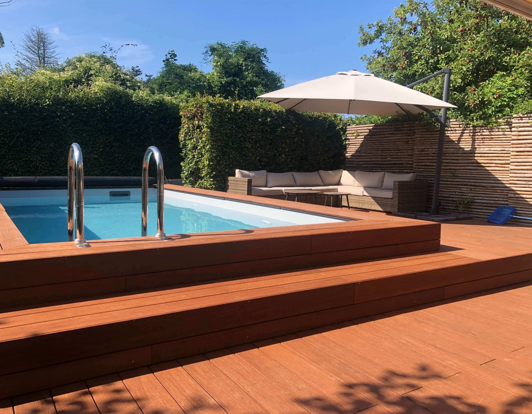 Großzügige Poolterrasse mit eingelassenem Swimmingpool, gemütlicher Lounge, Sonnenschirm und Essbereich in einem gepflegten Garten.